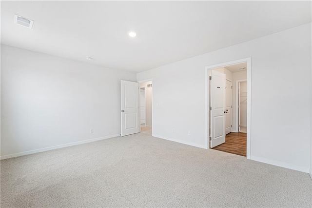 unfurnished room featuring carpet, visible vents, and baseboards
