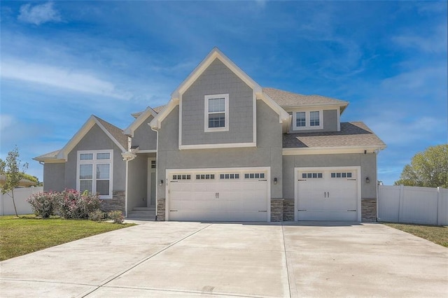 view of front of home with a garage, concrete driveway, stone siding, fence, and stucco siding