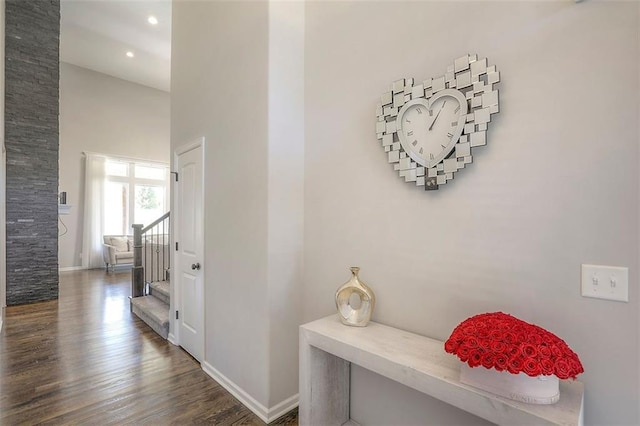 hall featuring dark wood-style floors, recessed lighting, baseboards, and stairs