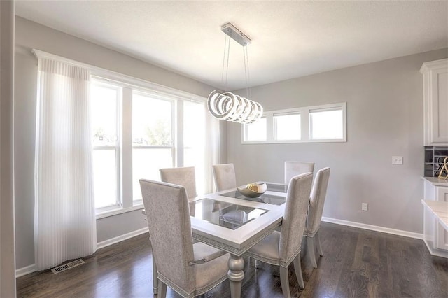 dining area with a wealth of natural light, dark wood-style flooring, and visible vents