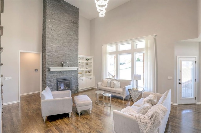 living area with baseboards, a fireplace, wood finished floors, and a healthy amount of sunlight