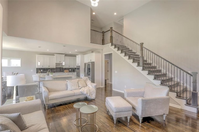 living area with stairs, baseboards, dark wood-type flooring, and recessed lighting