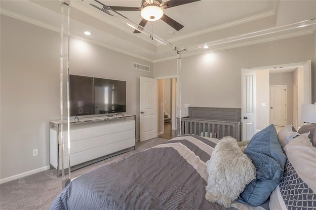 carpeted bedroom with baseboards, a tray ceiling, and crown molding