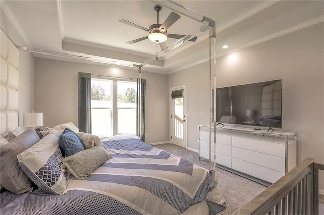 carpeted bedroom with ornamental molding, a raised ceiling, and baseboards