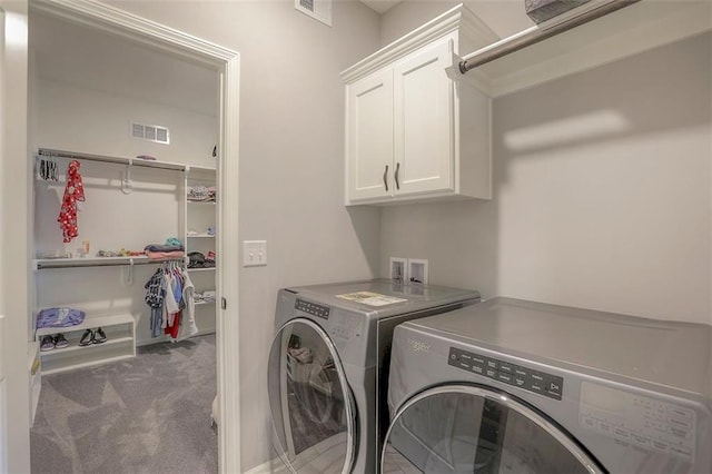 washroom featuring cabinet space, carpet, visible vents, and washer and dryer