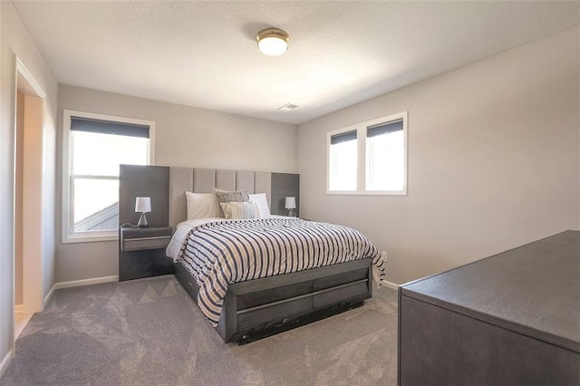 bedroom with carpet floors, a textured ceiling, and baseboards