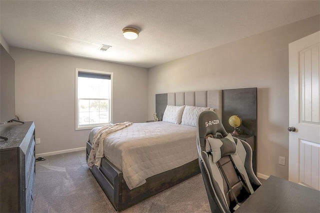 bedroom with a textured ceiling, dark colored carpet, visible vents, and baseboards