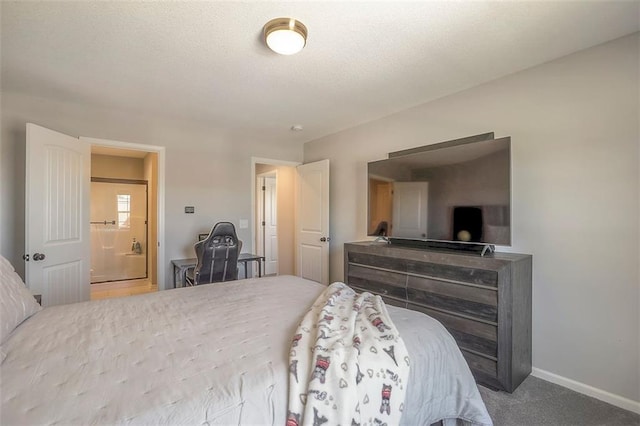 carpeted bedroom with a textured ceiling, ensuite bathroom, and baseboards