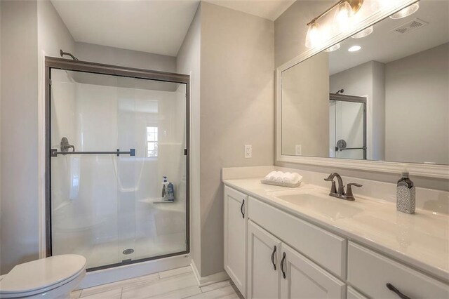 full bathroom featuring toilet, a shower stall, visible vents, and vanity