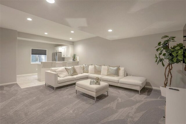 living area with light carpet, baseboards, and recessed lighting