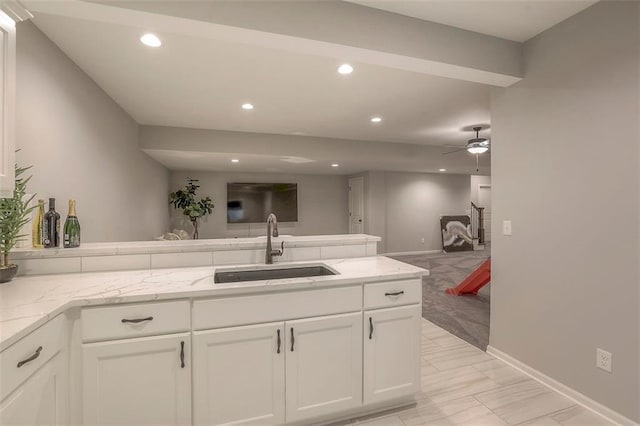 kitchen with open floor plan, a peninsula, a sink, and recessed lighting