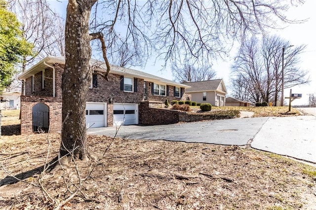 view of front of house with concrete driveway, brick siding, and an attached garage