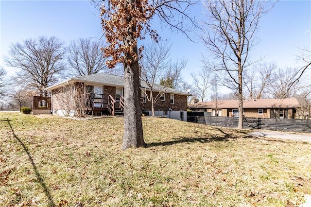 exterior space featuring a yard, brick siding, and fence