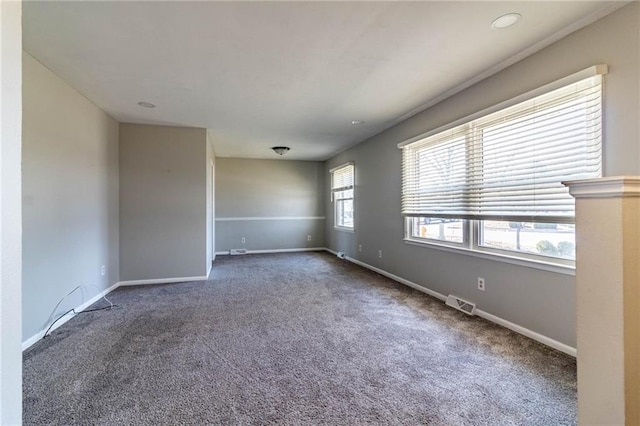 carpeted empty room featuring visible vents and baseboards