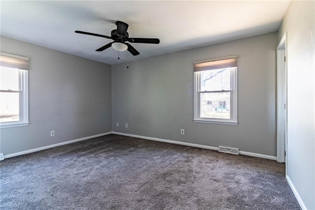 carpeted spare room featuring a ceiling fan, visible vents, and baseboards