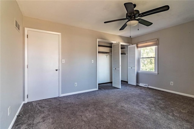 unfurnished bedroom with dark colored carpet, visible vents, and baseboards