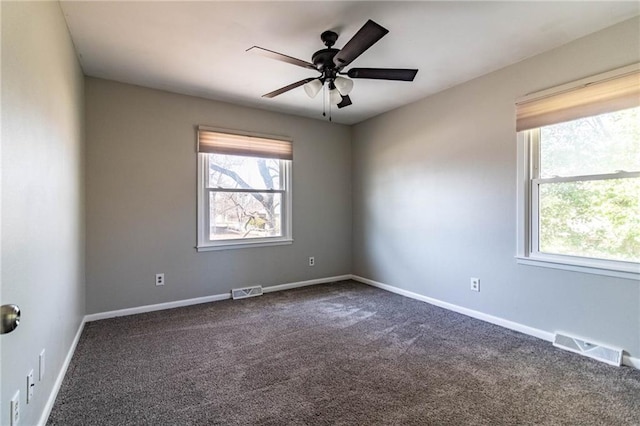 unfurnished room featuring dark colored carpet, a ceiling fan, visible vents, and baseboards