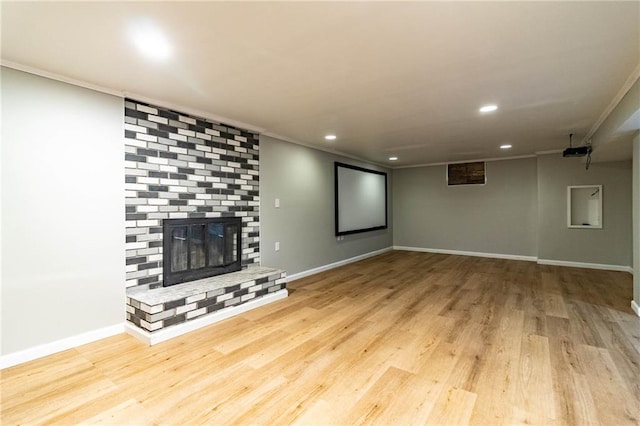 unfurnished living room featuring crown molding, recessed lighting, a brick fireplace, wood finished floors, and baseboards