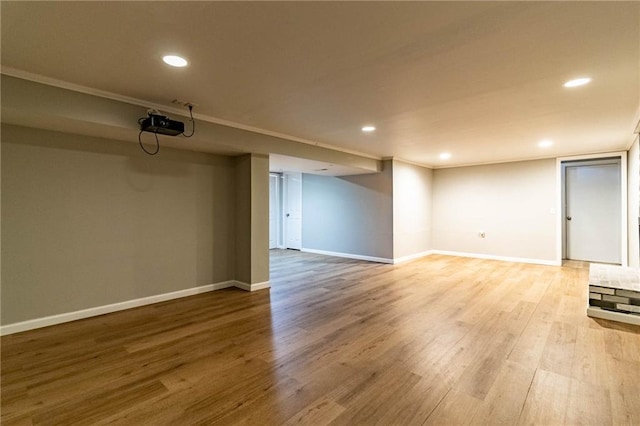 finished basement featuring light wood-style floors, recessed lighting, and baseboards