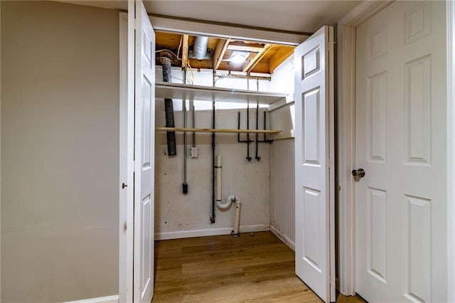 washroom featuring light wood-style floors, baseboards, and laundry area