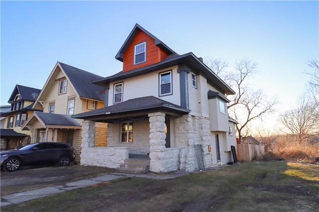 american foursquare style home featuring stone siding