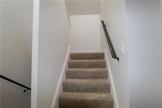 staircase with carpet floors and baseboards