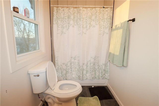 bathroom featuring toilet, shower / bathtub combination with curtain, baseboards, and tile patterned floors