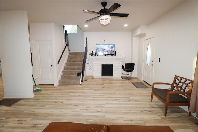 interior space with light wood finished floors, a fireplace, stairway, and recessed lighting