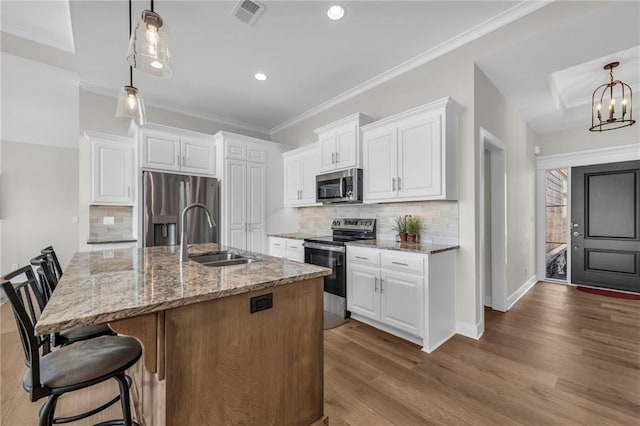 kitchen featuring a sink, light stone countertops, visible vents, and stainless steel appliances