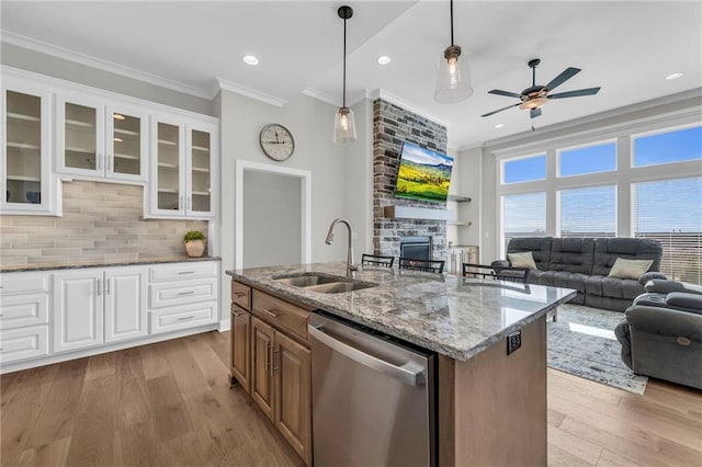 kitchen featuring ceiling fan, ornamental molding, a sink, dishwasher, and open floor plan