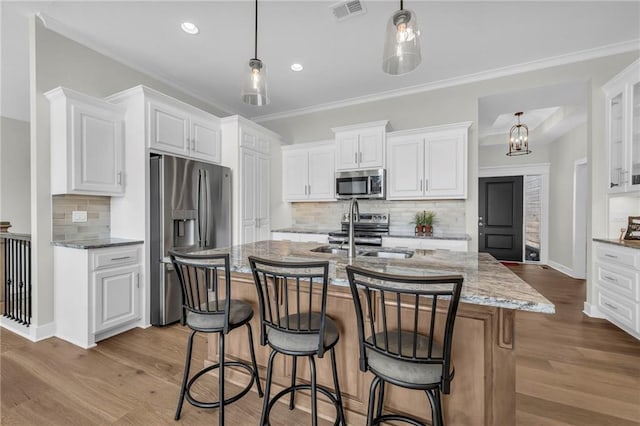 kitchen with wood finished floors, visible vents, appliances with stainless steel finishes, and a sink