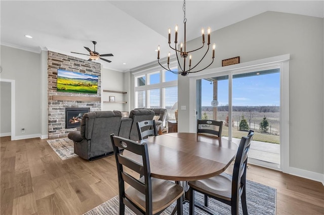 dining area with wood finished floors, ceiling fan with notable chandelier, and a healthy amount of sunlight