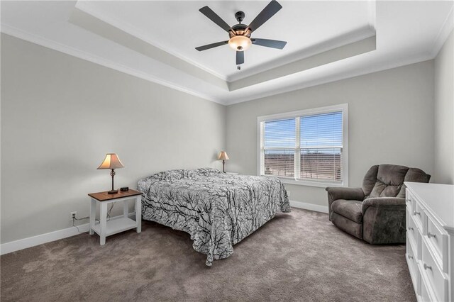 carpeted bedroom featuring baseboards, a raised ceiling, ceiling fan, and crown molding