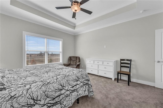 carpeted bedroom with ceiling fan, a raised ceiling, baseboards, and ornamental molding