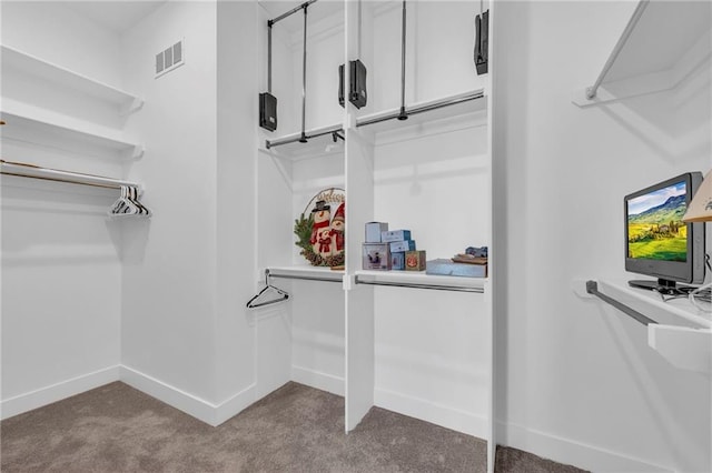 spacious closet with visible vents and dark colored carpet