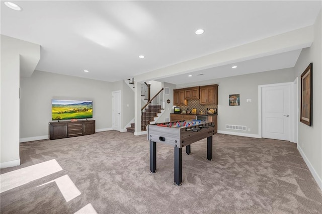 game room with light carpet, visible vents, and baseboards