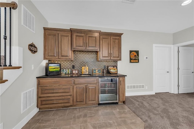 bar with visible vents, beverage cooler, and decorative backsplash