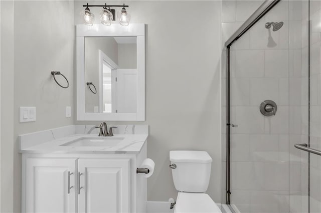 bathroom with a stall shower, toilet, and vanity