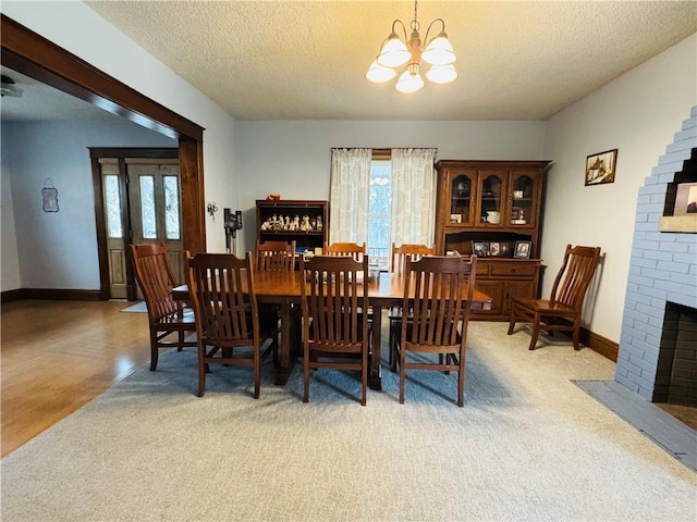 dining space with a fireplace, baseboards, a wealth of natural light, and a textured ceiling