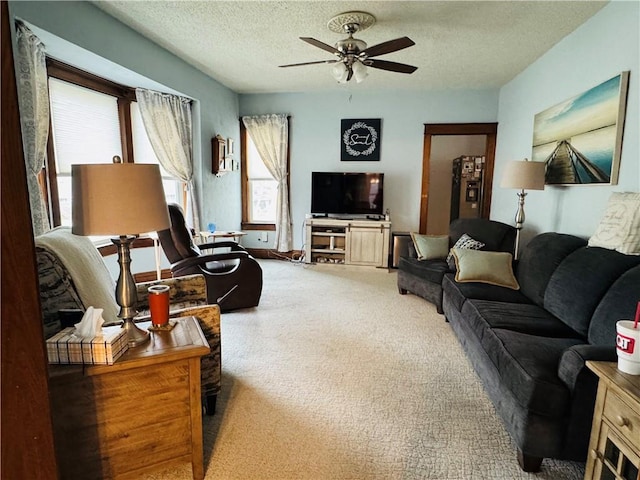 living area featuring a textured ceiling, ceiling fan, and carpet floors