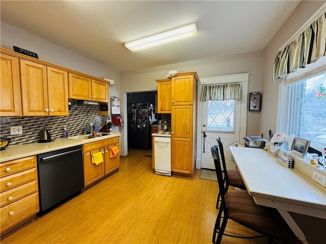 kitchen with dishwasher, light wood-style flooring, freestanding refrigerator, stove, and a sink