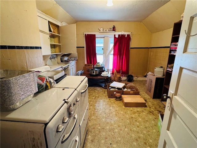 interior space featuring wainscoting, tile walls, and lofted ceiling