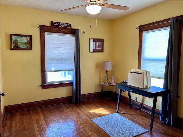 office featuring a ceiling fan, baseboards, and hardwood / wood-style flooring