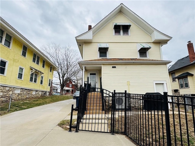 view of front of home with a fenced front yard and a gate