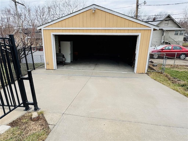 detached garage with fence and freestanding refrigerator