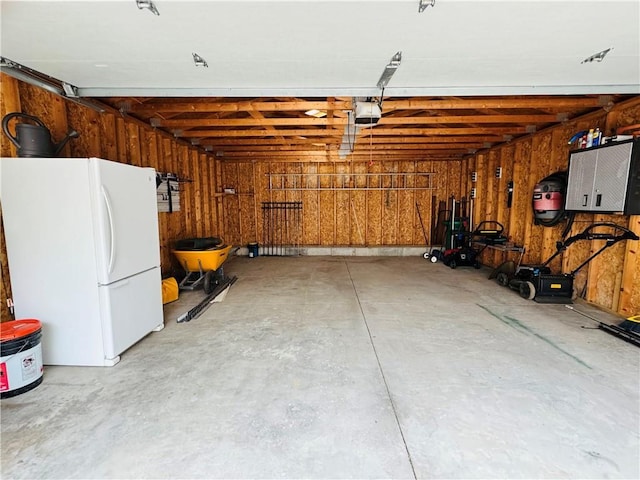 garage with a garage door opener and freestanding refrigerator