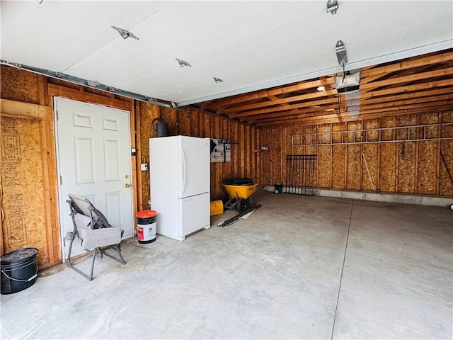 garage featuring a garage door opener and freestanding refrigerator