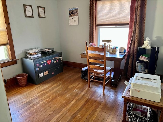 dining space with baseboards, wood-type flooring, and plenty of natural light