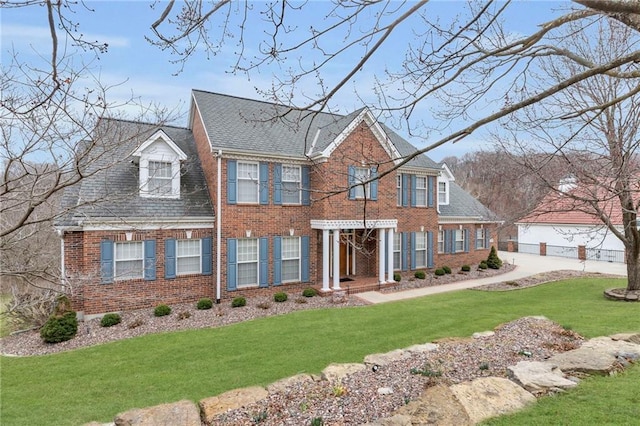 view of front facade featuring brick siding and a front yard