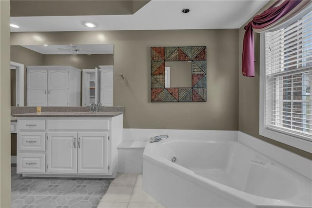 bathroom featuring a wealth of natural light, tile patterned floors, vanity, and a garden tub